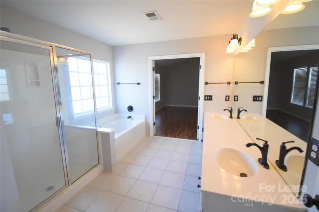 a bathroom with a tub sink and mirror