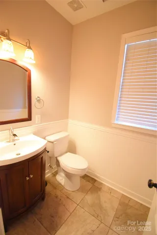 a bathroom with a double vanity sink toilet and mirror