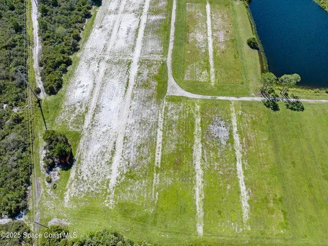 an aerial view of a house with garden space and street view