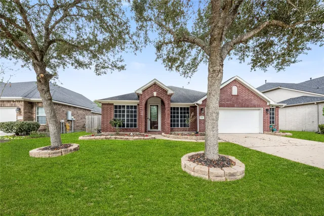 a front view of a house with a yard and trees