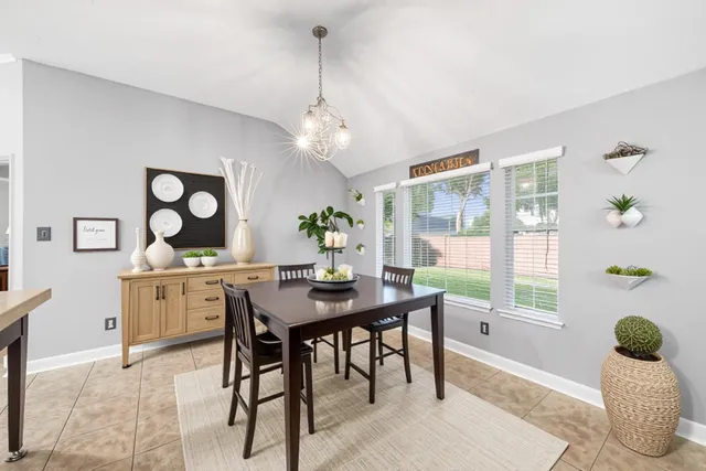 a view of a dining room with furniture a chandelier and wooden floor