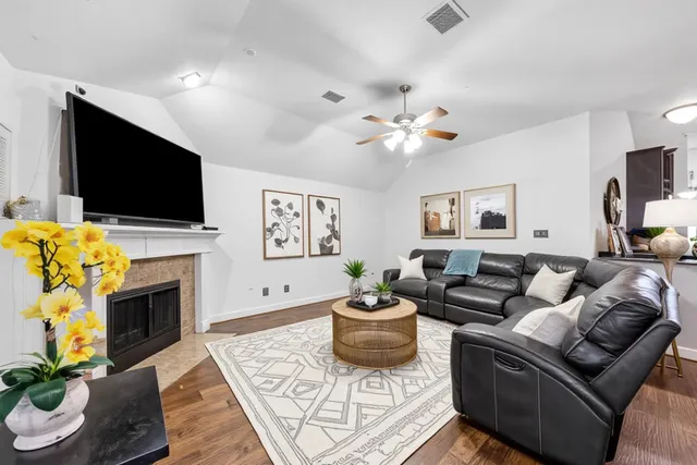a living room with furniture a flat screen tv and a fireplace
