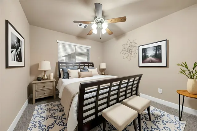 a bedroom with a bed and a lamp on dresser