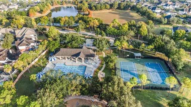 an aerial view of residential houses with outdoor space and trees