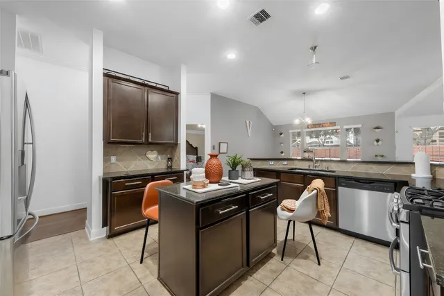 a kitchen that has a lot of counter space and stainless steel appliances