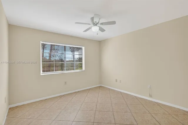an empty room with a ceiling fan and a window