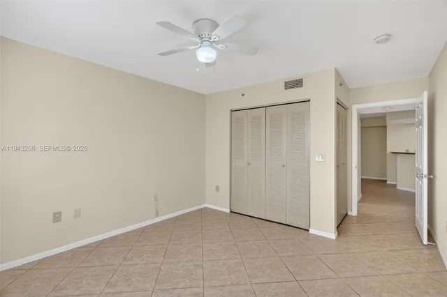 an empty room with windows and fan