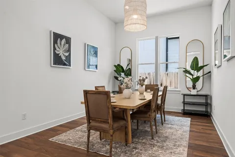 a view of a dining room with furniture a rug and wooden floor