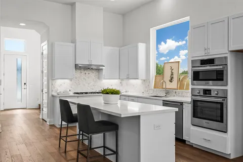 a kitchen with stainless steel appliances a stove a sink refrigerator and cabinets