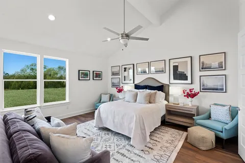 a bedroom with a large bed couch and a window