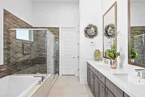 a spacious bathroom with a granite countertop tub a sink and a large mirror