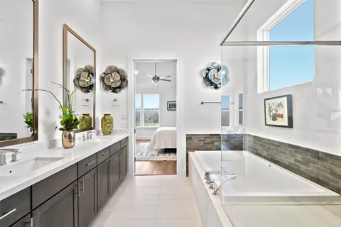 a spacious bathroom with a tub sink and mirror