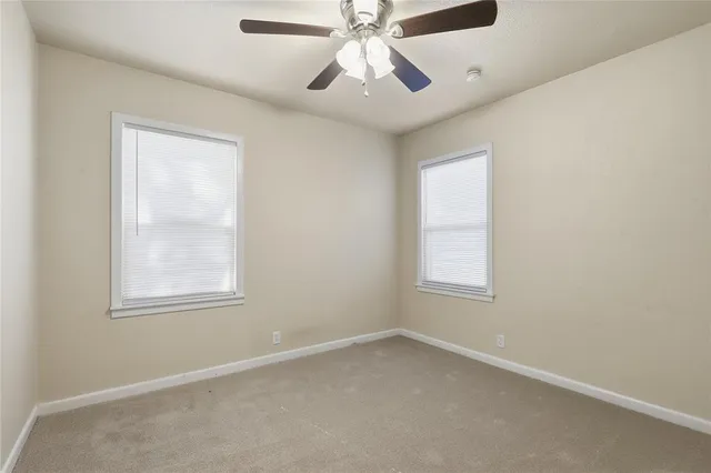 an empty room with a window and a fan