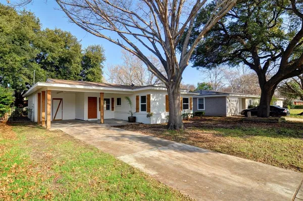 a view of a yard in front of a house with large tree
