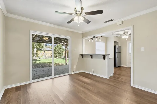 a view of an empty room with window and wooden floor