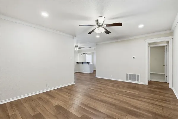a view of empty room with wooden floor and window