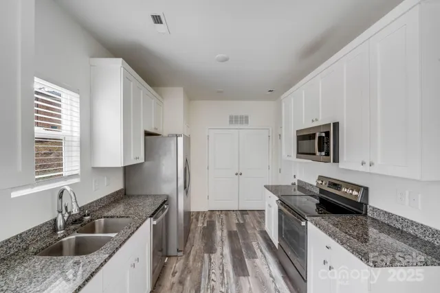 a kitchen that has a sink and a stove top oven