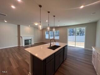6104 Adecor Way Raleigh, NC 27617 - Photo 21 of 37 a kitchen with a sink a chandelier and wooden floor