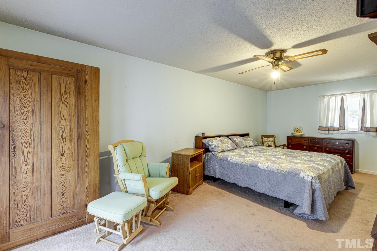 2822 Ellis Road Durham, NC 27703 - Photo 25 of 37 a bedroom with a bed and a chandelier