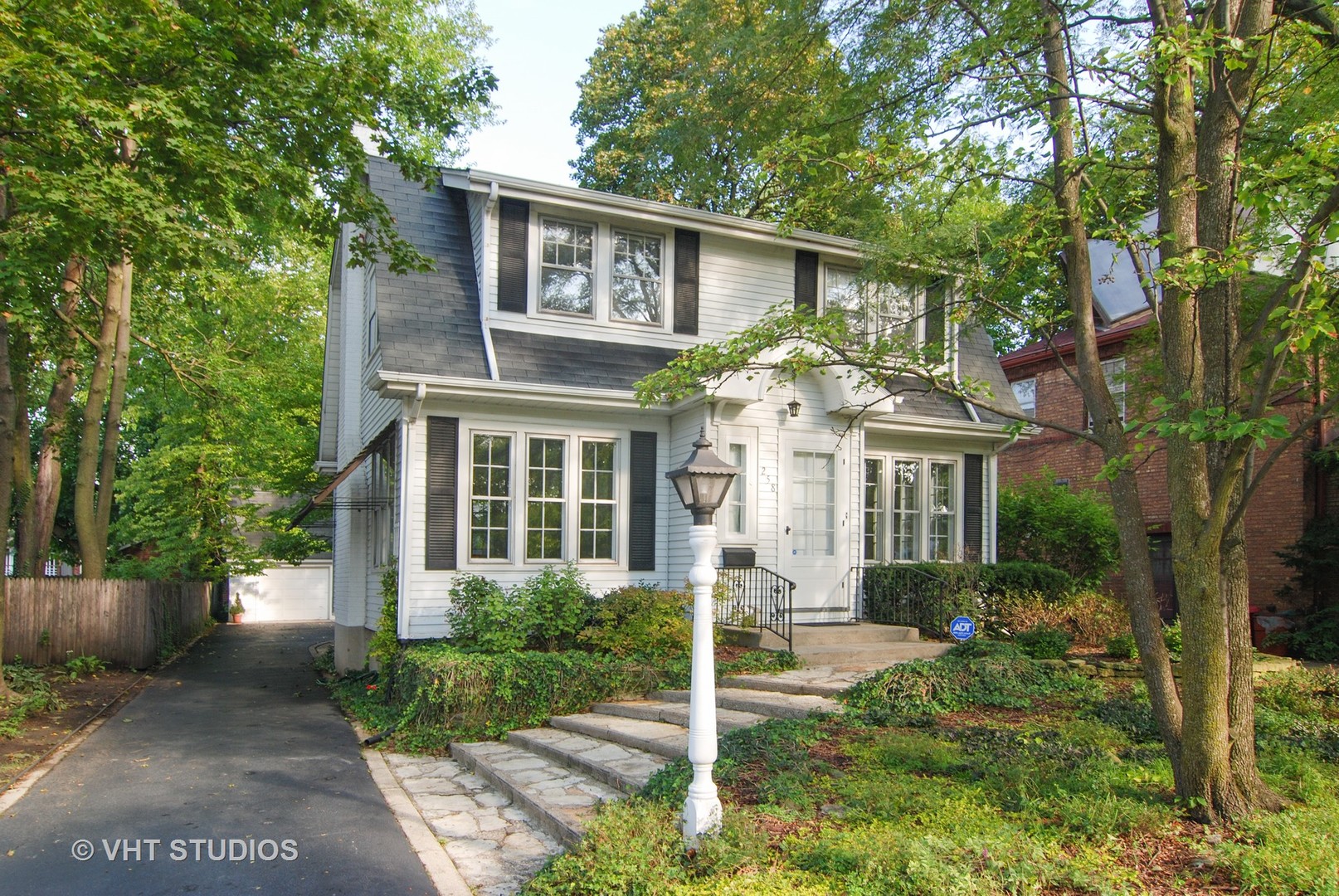 258 Lionel Road Riverside, IL 60546 - Photo 1 of 20 a view of a brick house with a yard and plants