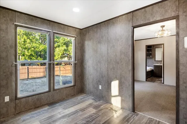 a view of a livingroom with wooden floor and a bathroom