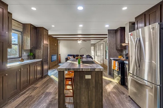 a kitchen with stainless steel appliances granite countertop a refrigerator a stove and a sink
