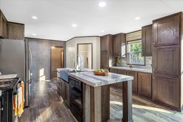 a kitchen with stainless steel appliances granite countertop a stove a refrigerator and a wooden cabinets