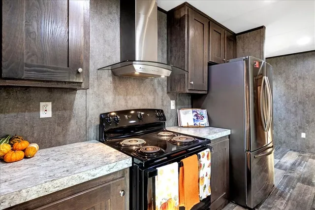 a kitchen with stainless steel appliances granite countertop a refrigerator and a stove