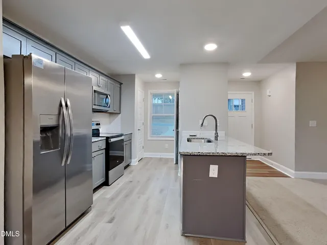 a kitchen with kitchen island a counter top space and stainless steel appliances