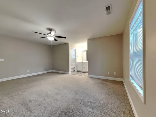 a view of an empty room with a chandelier fan