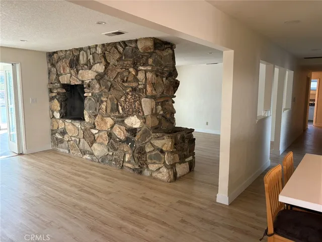 a view of an empty room with a fireplace and a window