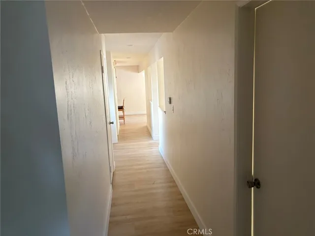 an empty room with wooden floor closet and windows