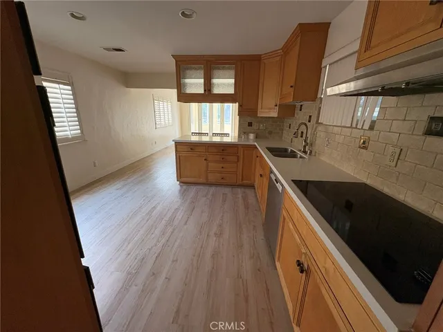 a view of a kitchen with a sink a window and wooden floor