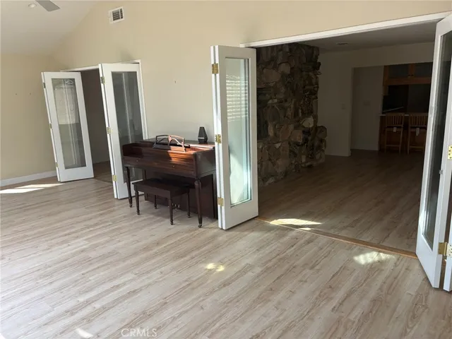 a view of a hallway with wooden floor and a livingroom