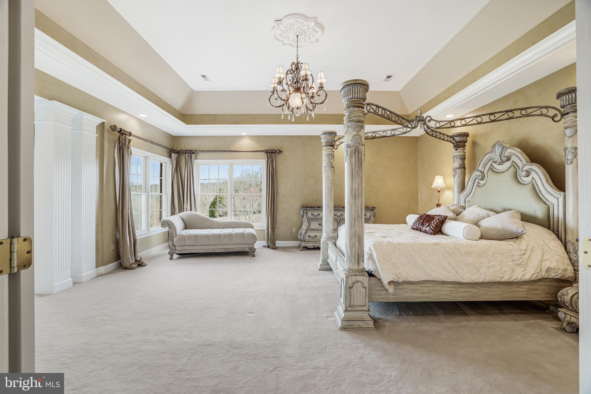 22609 Hillside Circle Leesburg, VA 20175 - Photo 76 of 110 a spacious bedroom with a bed and a chandelier