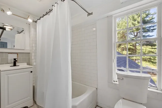a bathroom with a bathtub a window and a shower