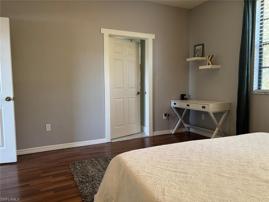 14908 Summit Pl Circle, Unit 26 Naples, FL 34119 - Photo 18 of 26 a bedroom with a bed and wooden floor