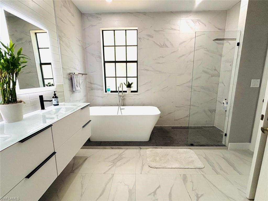 14908 Summit Pl Circle, Unit 26 Naples, FL 34119 - Photo 21 of 26 a bathroom with a bathtub a sink and a shower