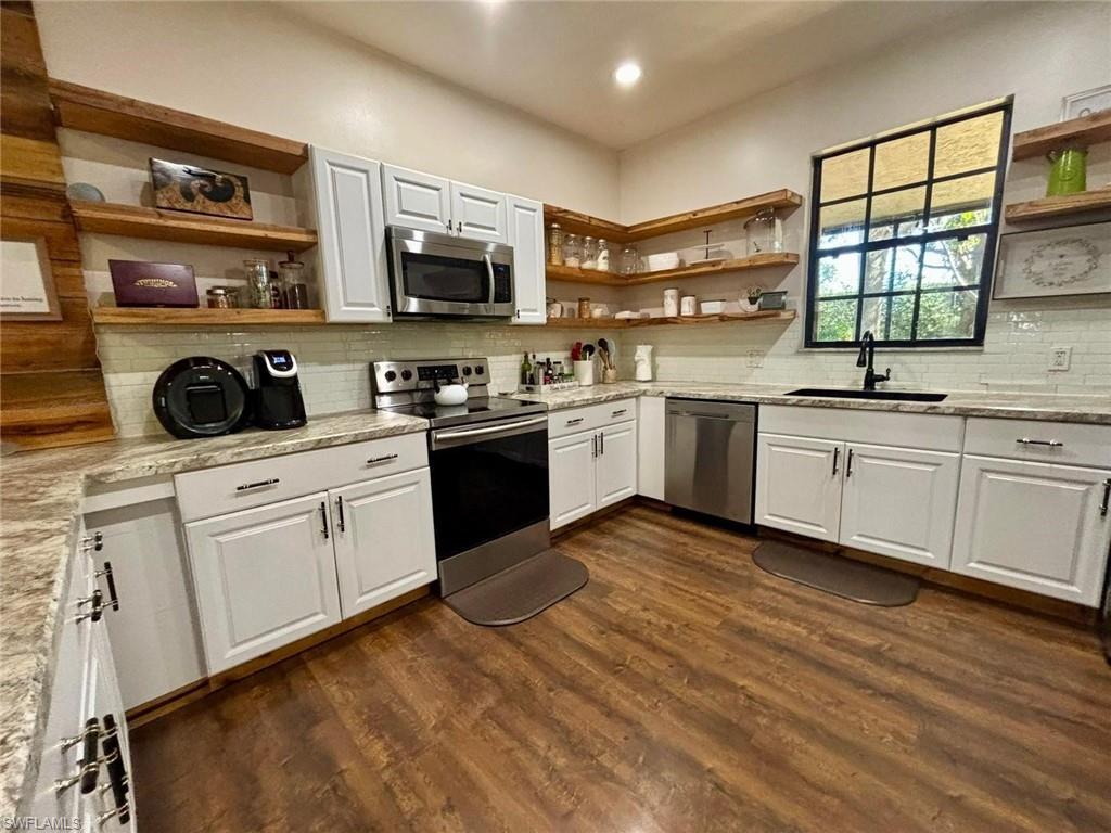 14908 Summit Pl Circle, Unit 26 Naples, FL 34119 - Photo 7 of 26 a kitchen with stainless steel appliances granite countertop a sink and cabinets