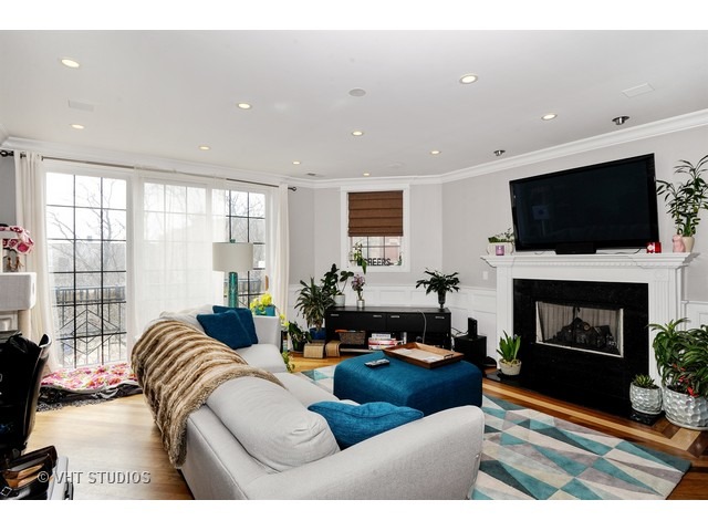 950 West Barry Avenue, Unit 3 Chicago, IL 60657 - Photo 2 of 10 a living room with furniture a fireplace and a flat screen tv