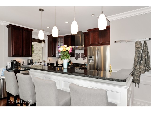 950 West Barry Avenue, Unit 3 Chicago, IL 60657 - Photo 3 of 10 a kitchen with kitchen island granite countertop a sink cabinets and stainless steel appliances