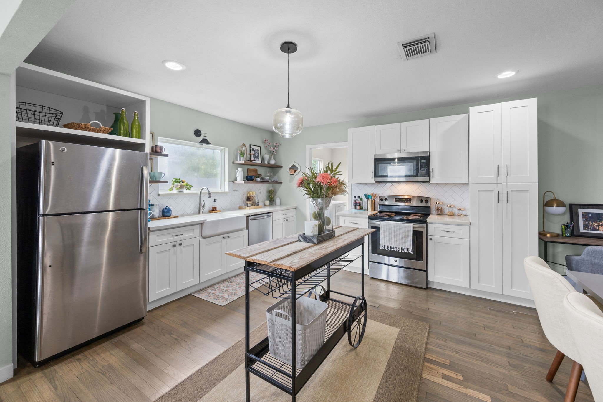 5519 Hillman Street Houston, TX 77023 - Photo 6 of 22 a kitchen with stainless steel appliances a refrigerator a stove a sink dishwasher and a refrigerator with wooden floor