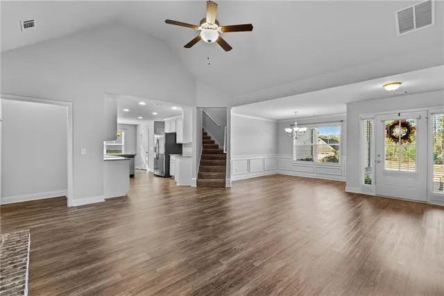 a view of an empty room with a window and wooden floor