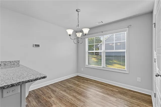a view of a livingroom with a chandelier fan and wooden floor