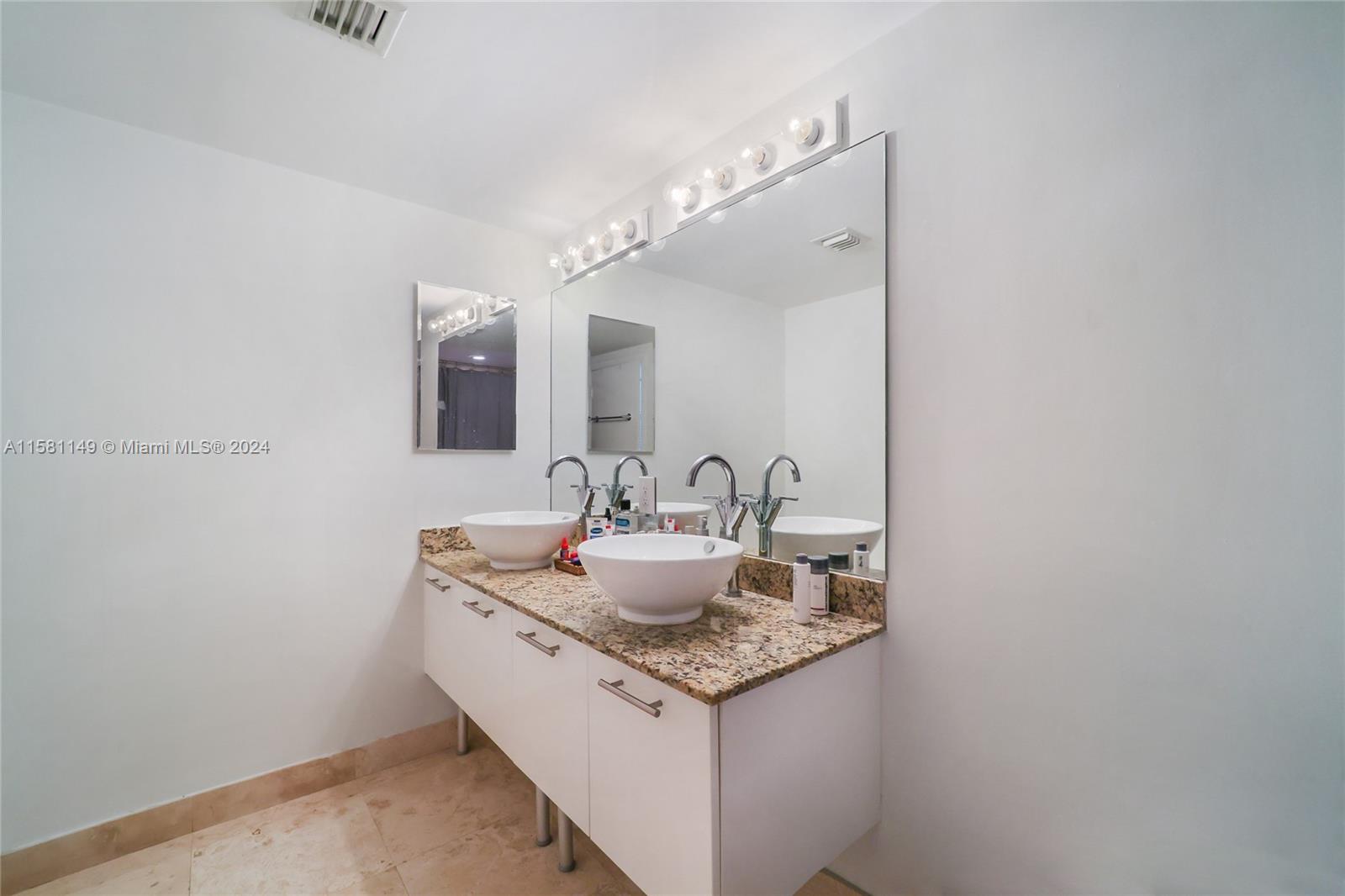 41 Southeast 5th Street, Unit 304 Miami, FL 33131 - Photo 13 of 16 a bathroom with a granite countertop sink and a mirror