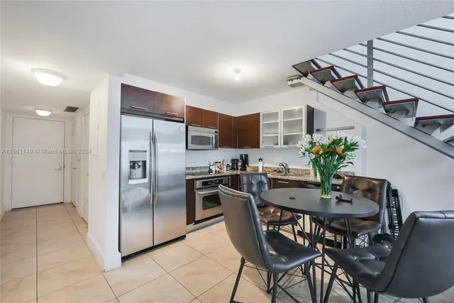a kitchen with granite countertop a table chairs stove and refrigerator