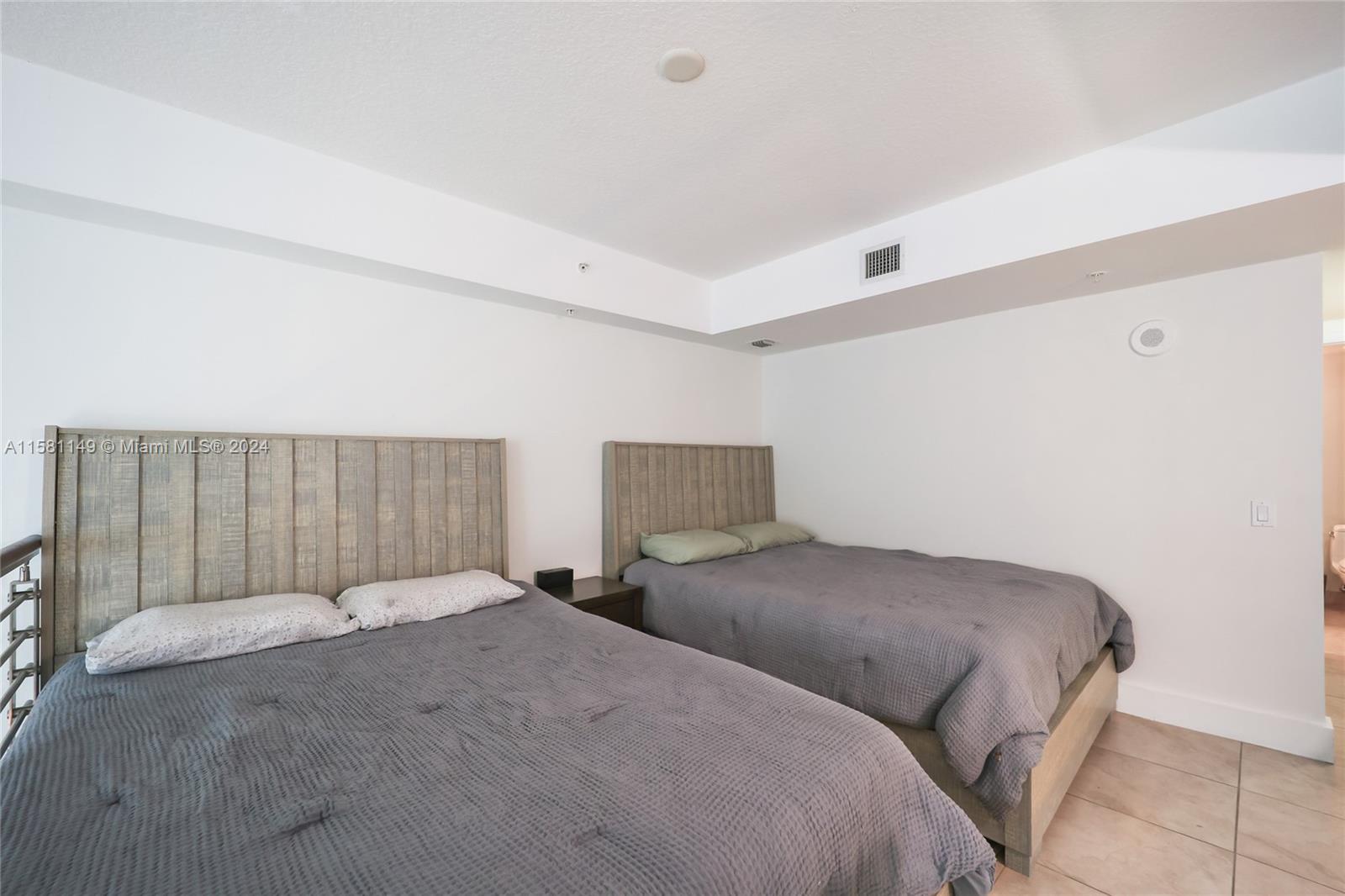 41 Southeast 5th Street, Unit 304 Miami, FL 33131 - Photo 10 of 16 a bedroom with bed and a night stand