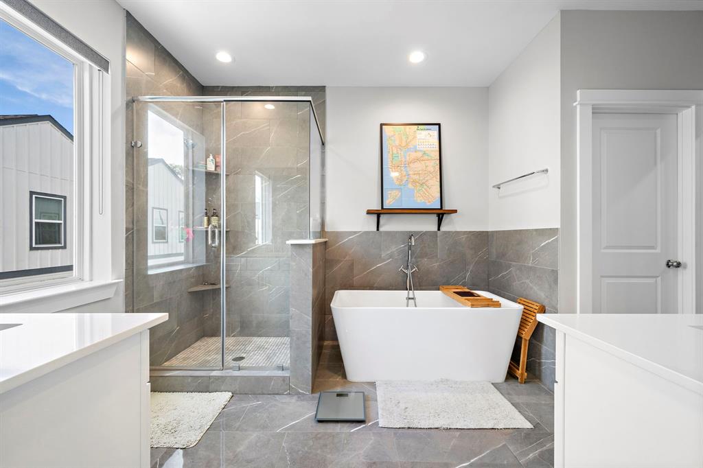 a white bath tub sitting in a bathroom and mirror