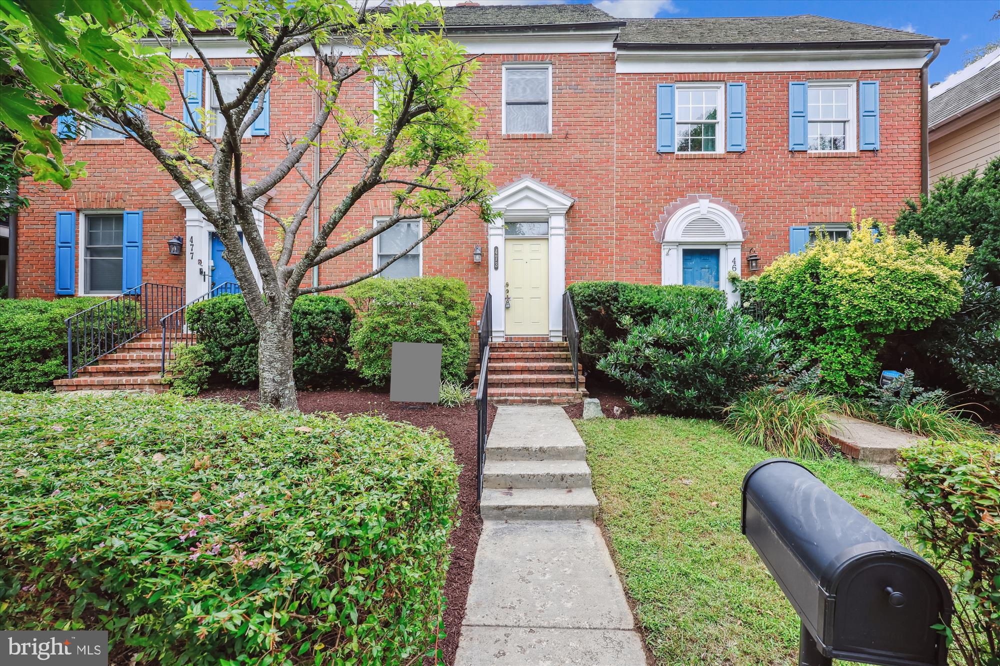 a front view of a house with a yard and potted plants
