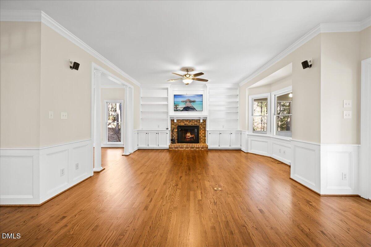 10708 Trappers Creek Drive Raleigh, NC 27614 - Photo 12 of 66 an empty room with wooden floor fireplace and windows